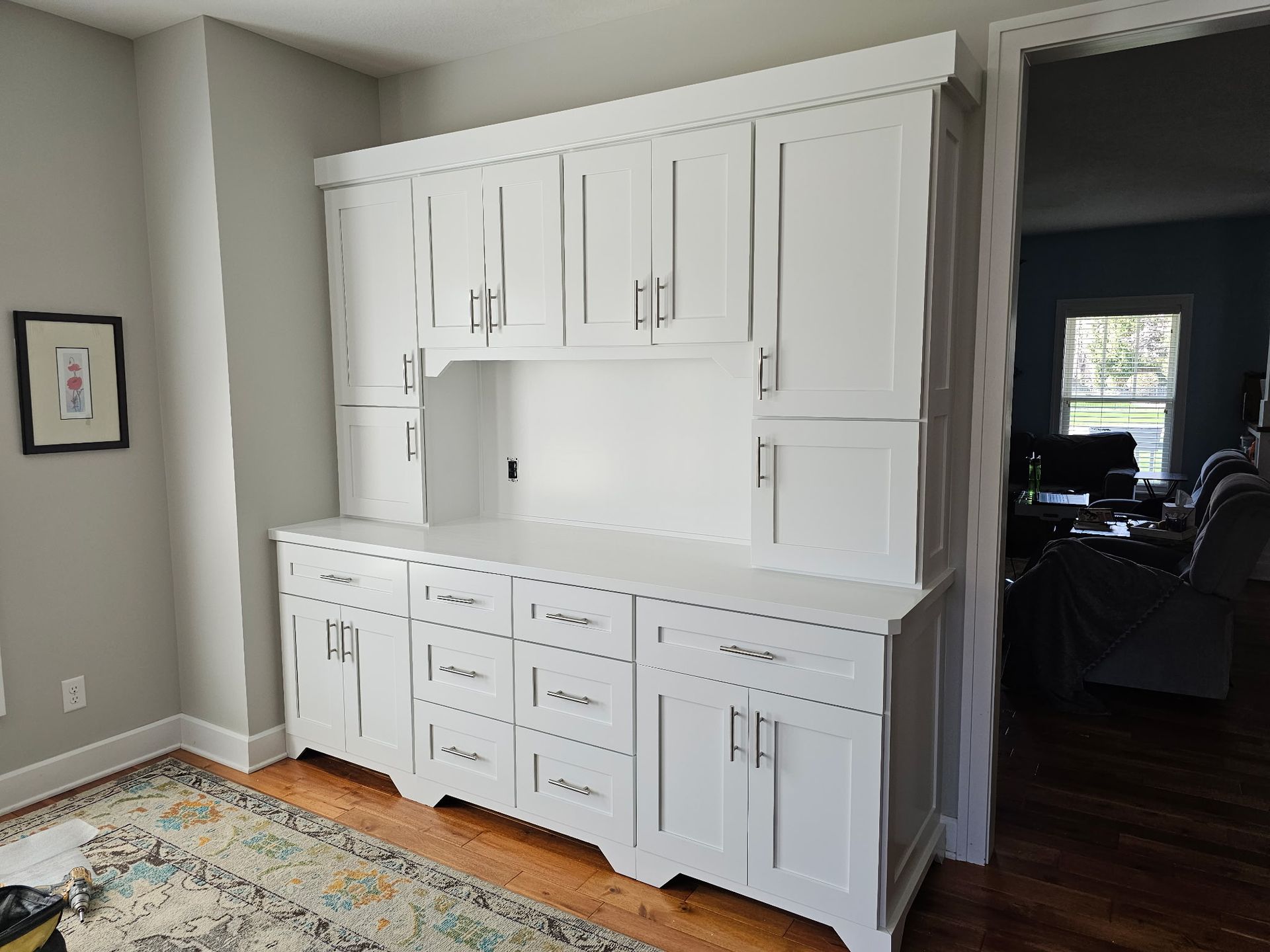 Kitchen under renovation with covered countertops, taped cabinets, and protective floor covering