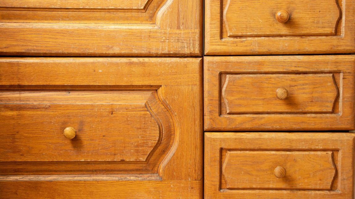 Wooden dresser drawers with brass knobs, one large drawer on the left and three smaller drawers on the right.