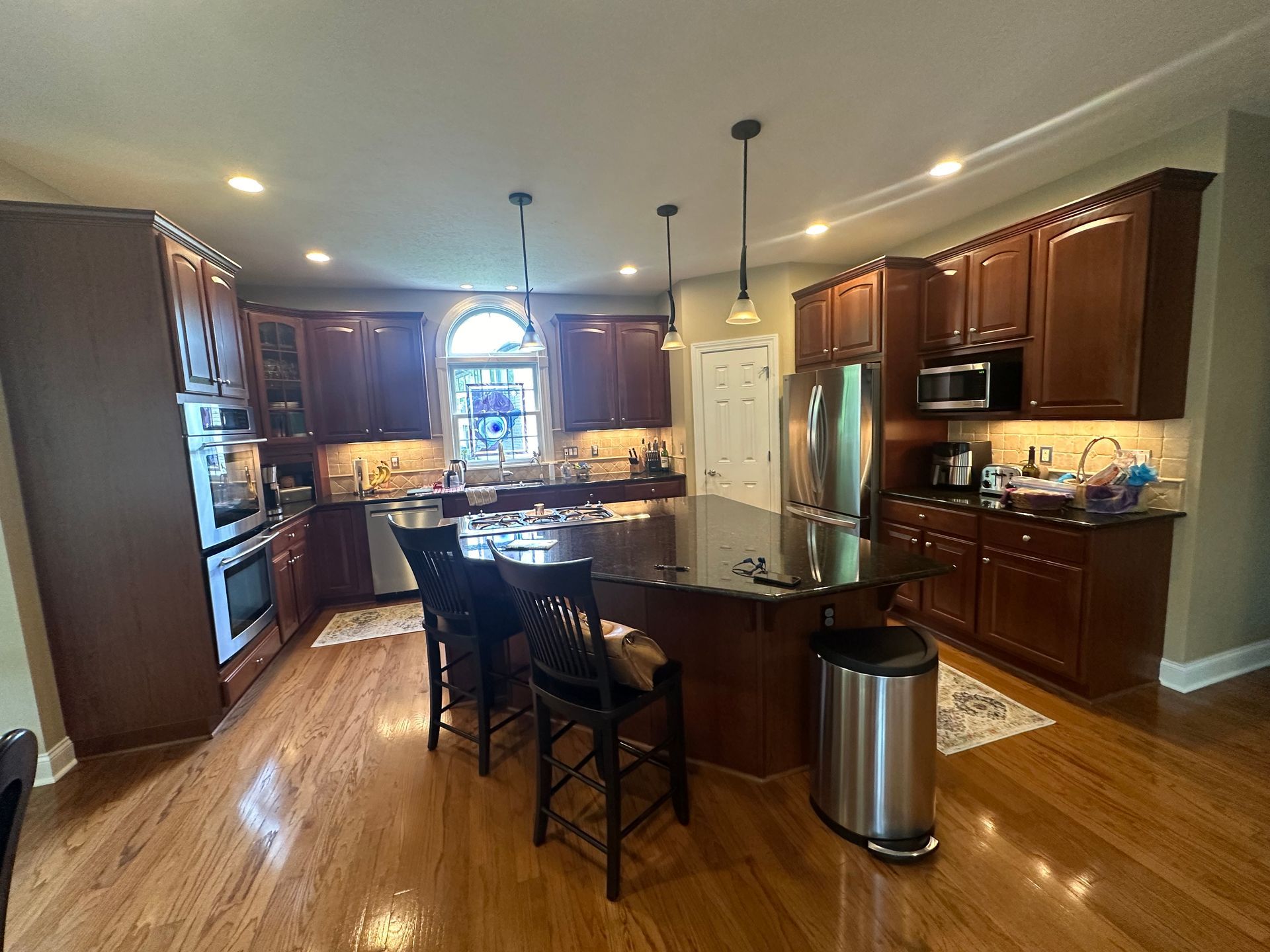 Kitchen under renovation with covered countertops, taped cabinets, and protective floor covering