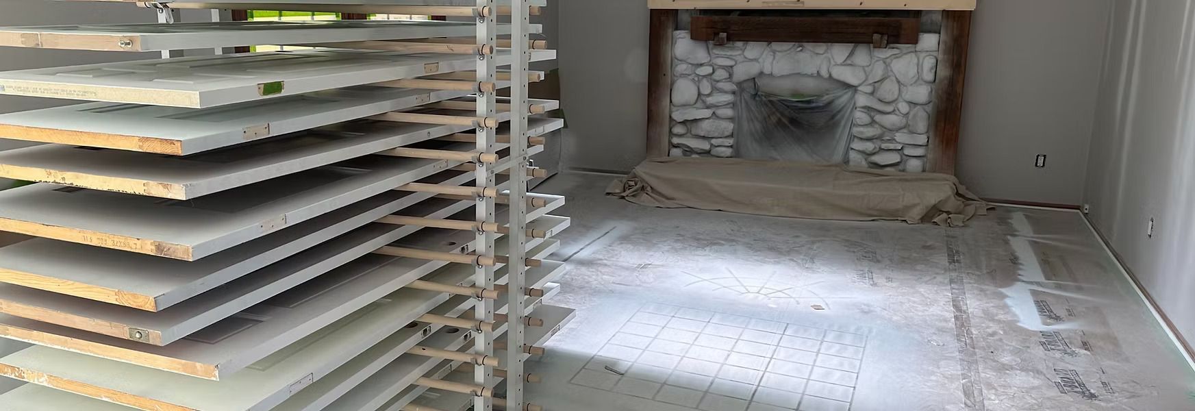 Dusty room with stacked trays on the left and a damaged fireplace at the back
