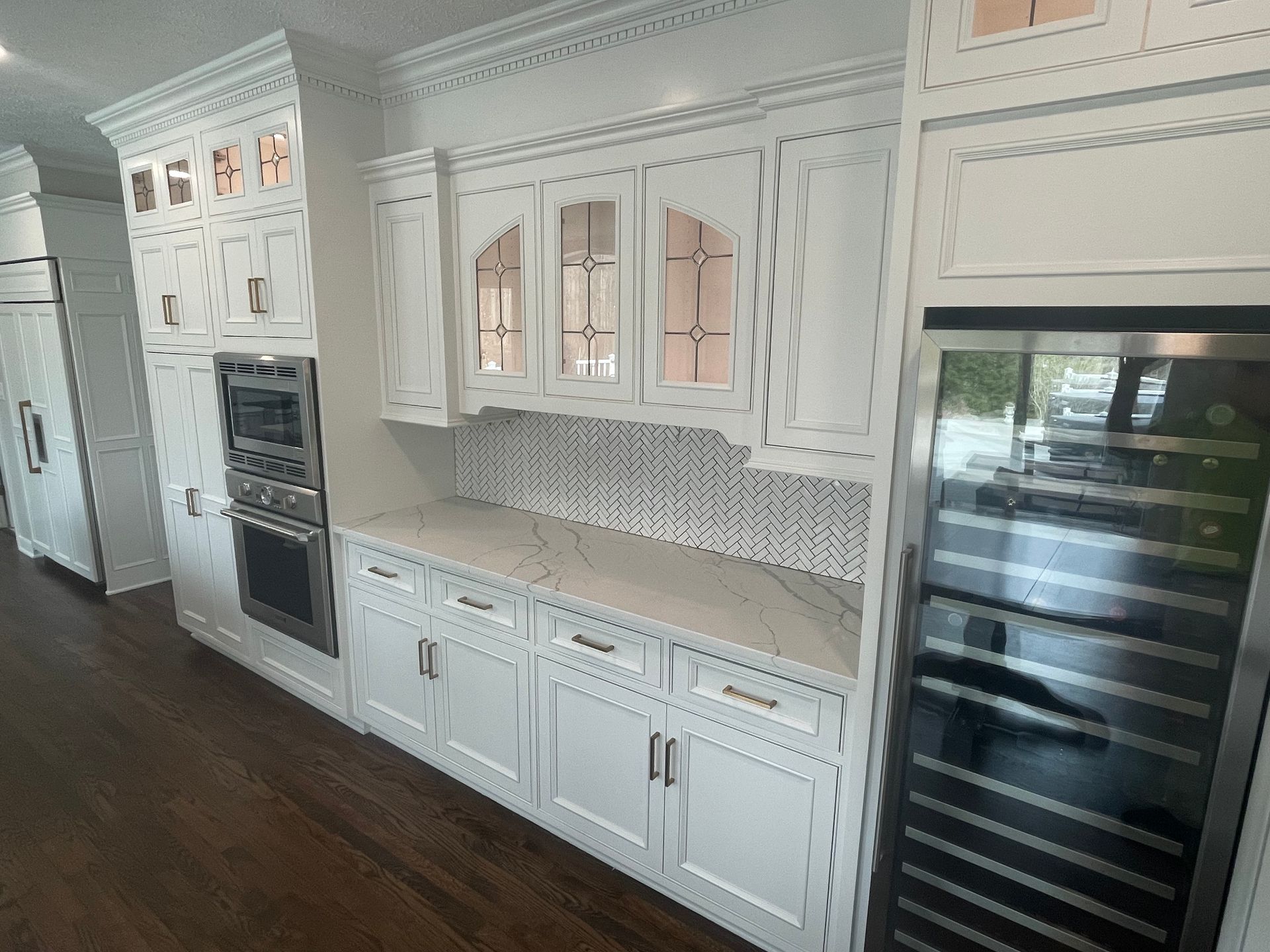 Kitchen under renovation with cabinets, tools, and hardwood floor being sanded and cleaned