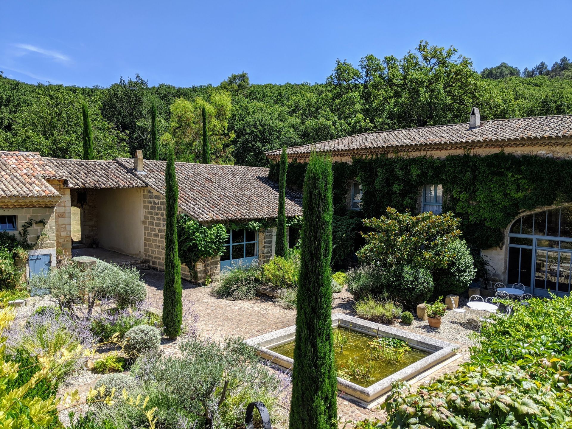Terraced Mediterranean garden with stone buildings and cypress trees at the retreat venue in southern France