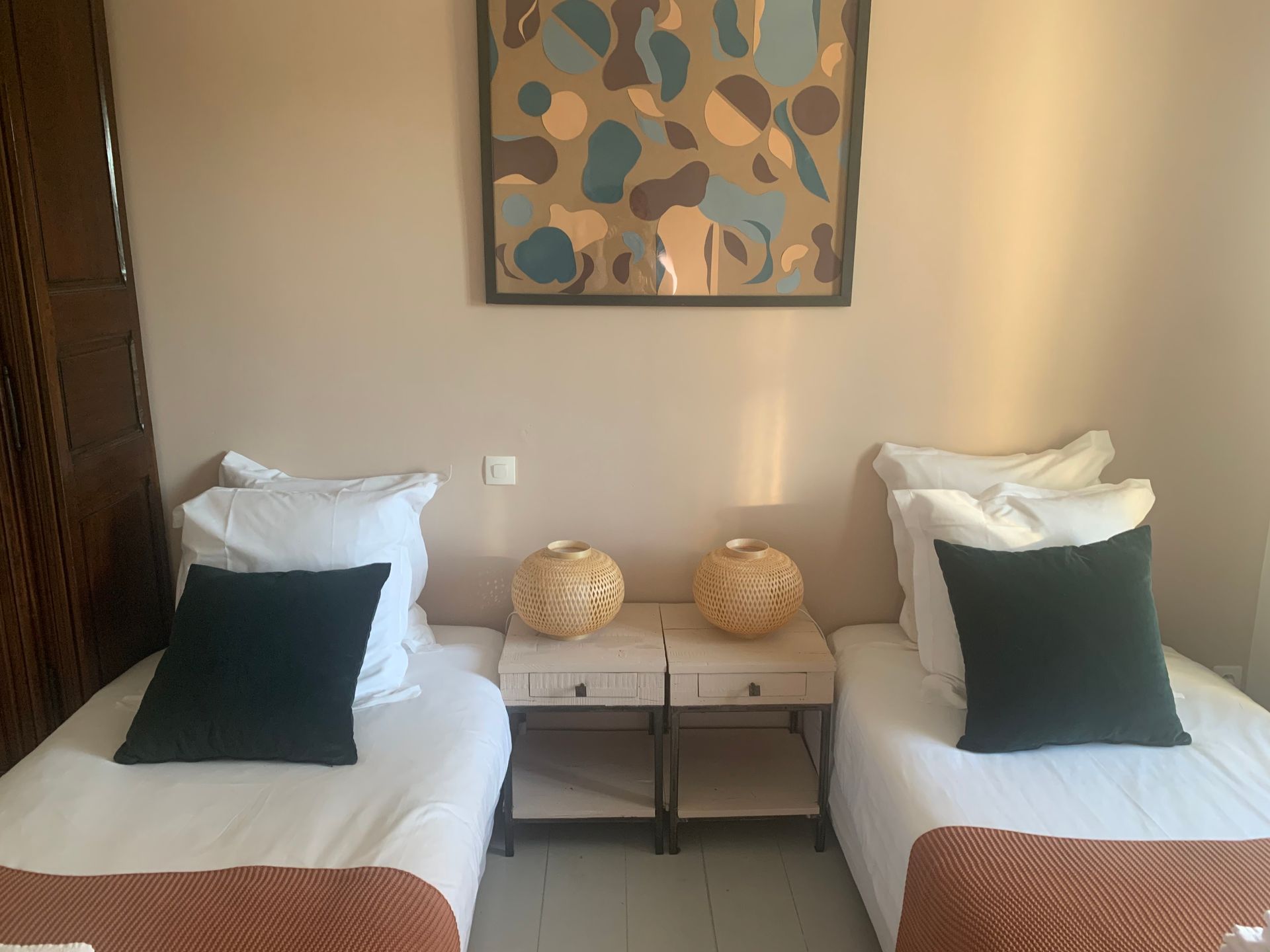 A bedroom with two beds , two nightstands and a painting on the wall. A lovely bedroom  at the Mas, Fleur de Lys Retreats.