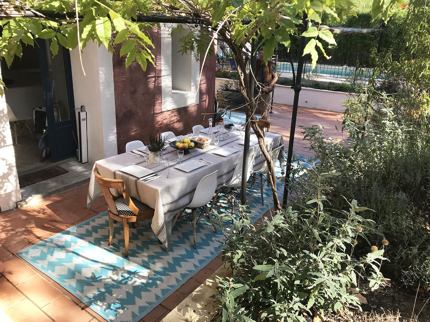 A patio with a table and chairs under a tree.