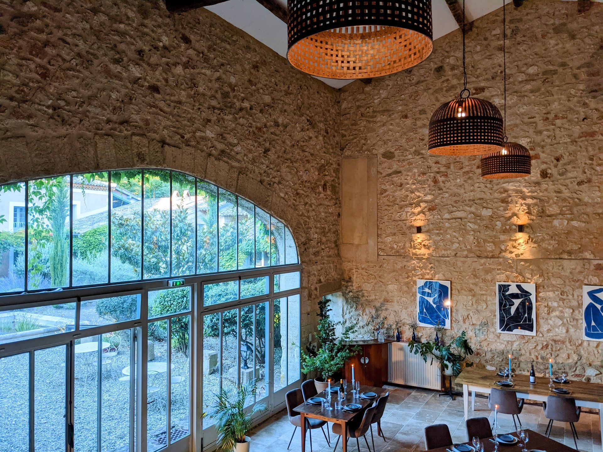 Rustic stone dining hall with arched windows,  a gathering space for The Art of Layers retreat in France.