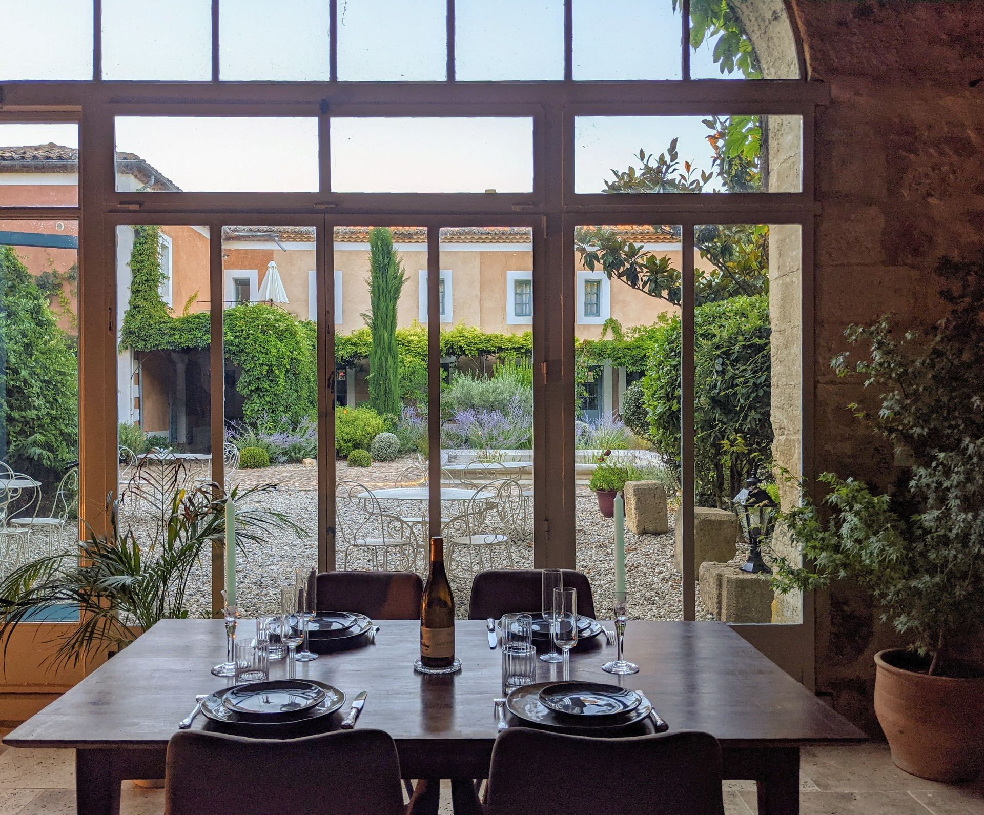 Elegant dining room with glass doors overlooking the garden, set for a shared retreat meal in Provence.
