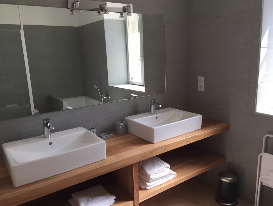 A bathroom with two sinks and a mirror