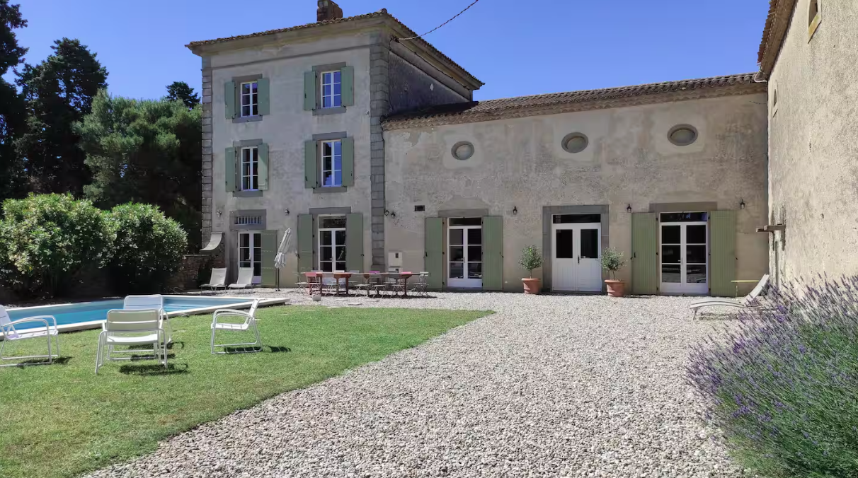 A large house with a swimming pool in front of it
