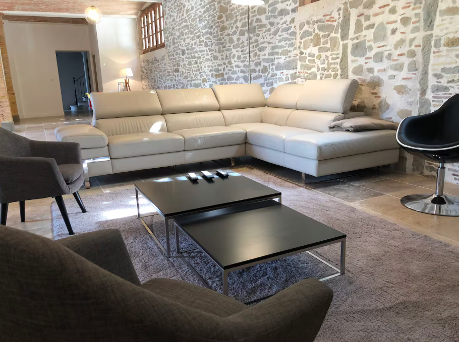 A living room with a couch , chairs , and a coffee table.