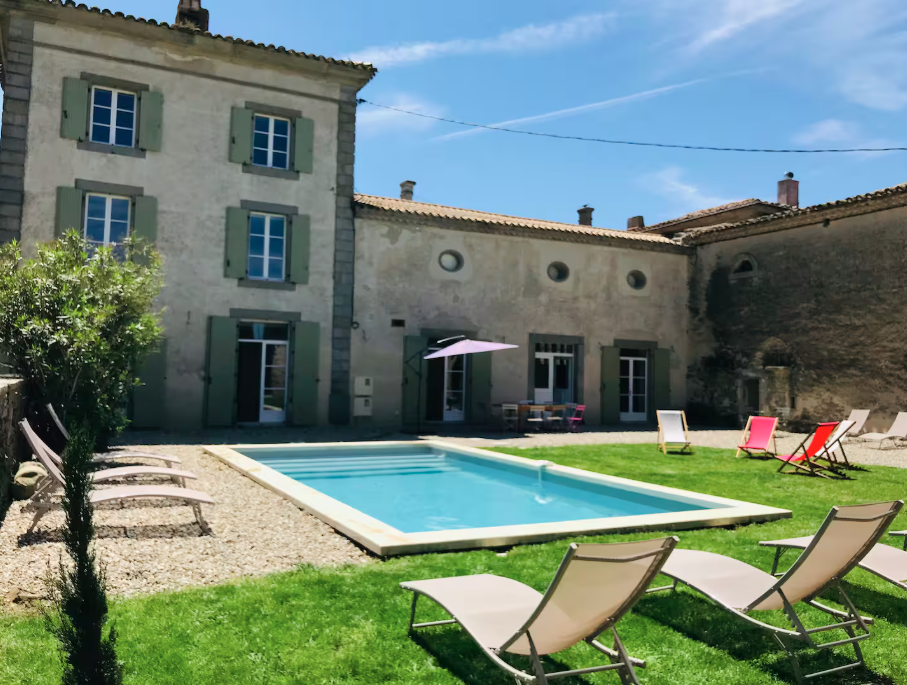 A large house with a swimming pool in front of it