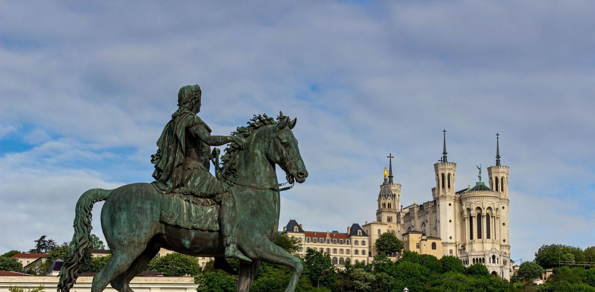A French statue of a man riding a horse in front of a castle. So french, Fleur de Lys Retreats.