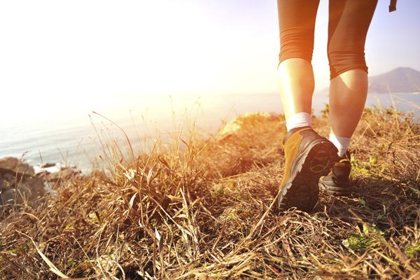 a person is walking on a hill near the ocean .