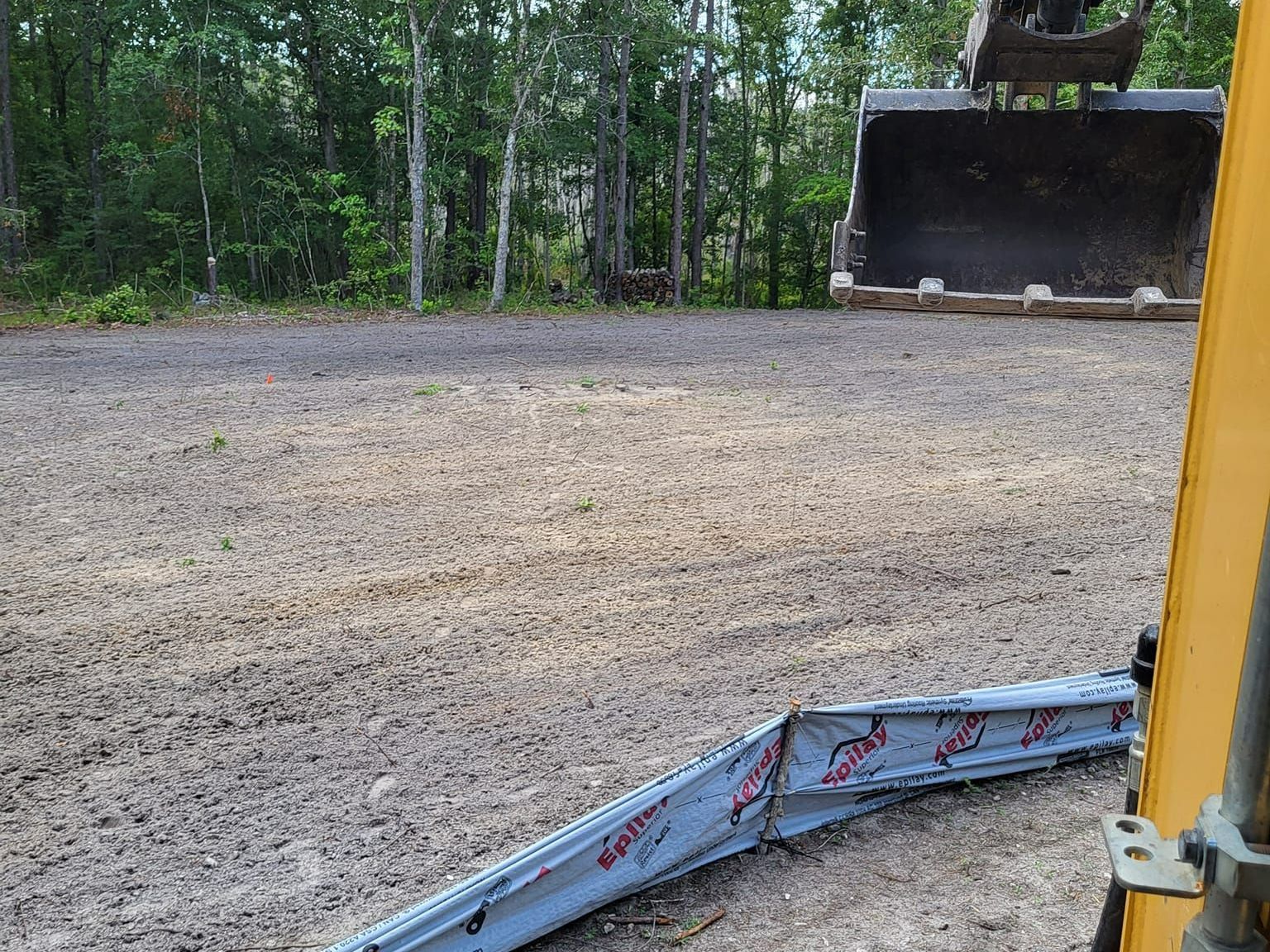 A piece of metal is laying on the ground next to a bulldozer.