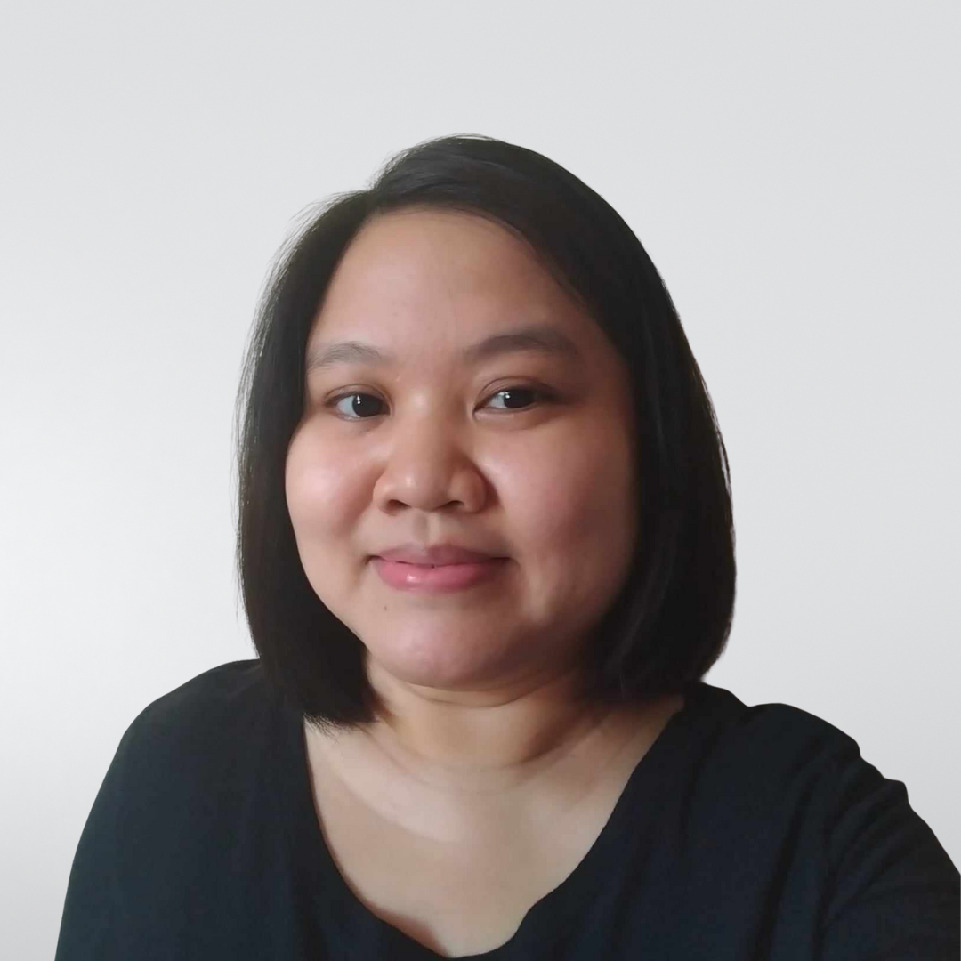 A person with dark, shoulder-length hair and a neutral expression, wearing a black shirt against a white background.