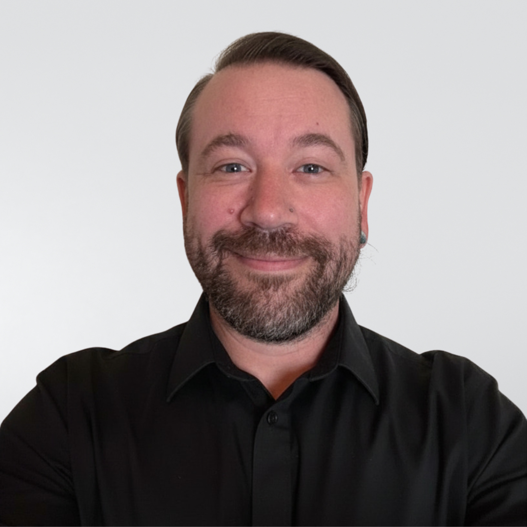Smiling man in a black shirt against a plain white background