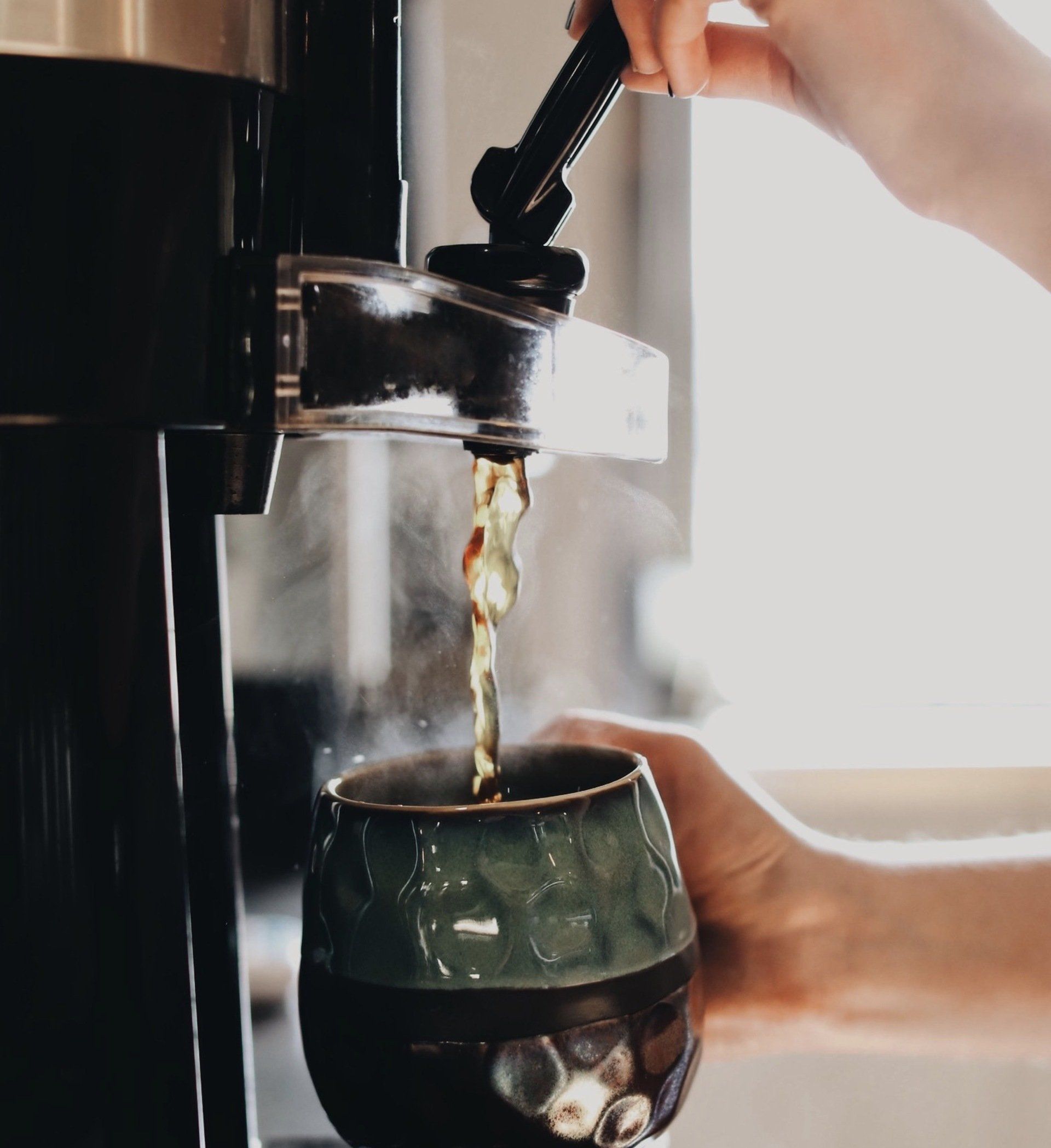 A person is pouring a drink into a cup
