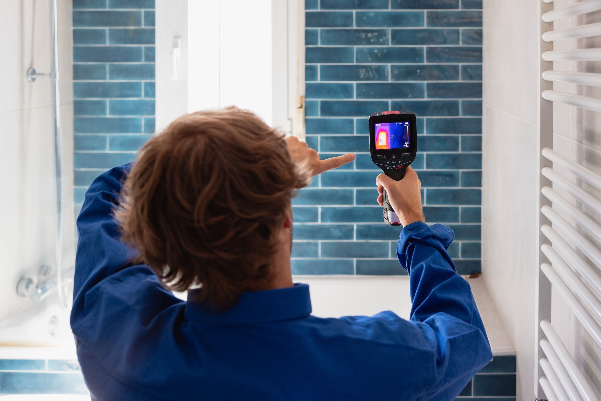 Technician performing thermal inspection for a possible leak in a bathroom. Technician performing thermal inspection for a possible leak in a bathroom.