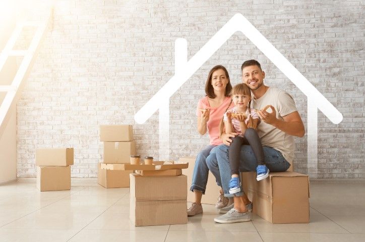 Family sitting on cardboard boxes in an empty space