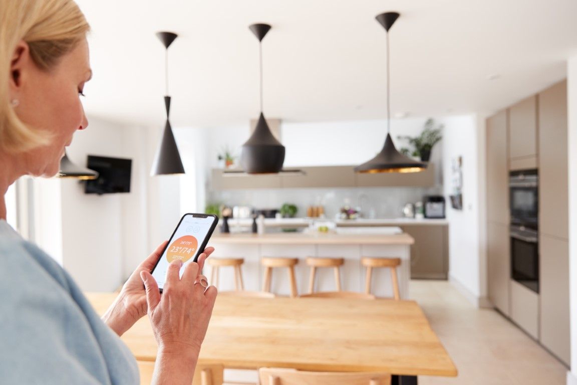 Woman changes central heating temperature via app