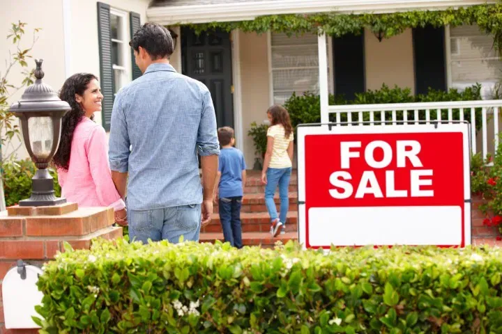 family smiling and walking into newly purchased home