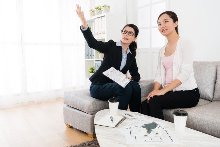 Appraisal discussion with an Agent and woman seated on a couch