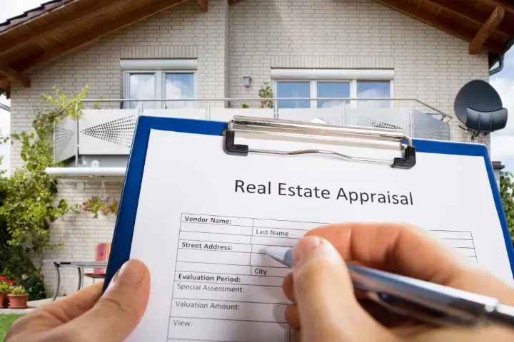 completing appraisal form in front of a house