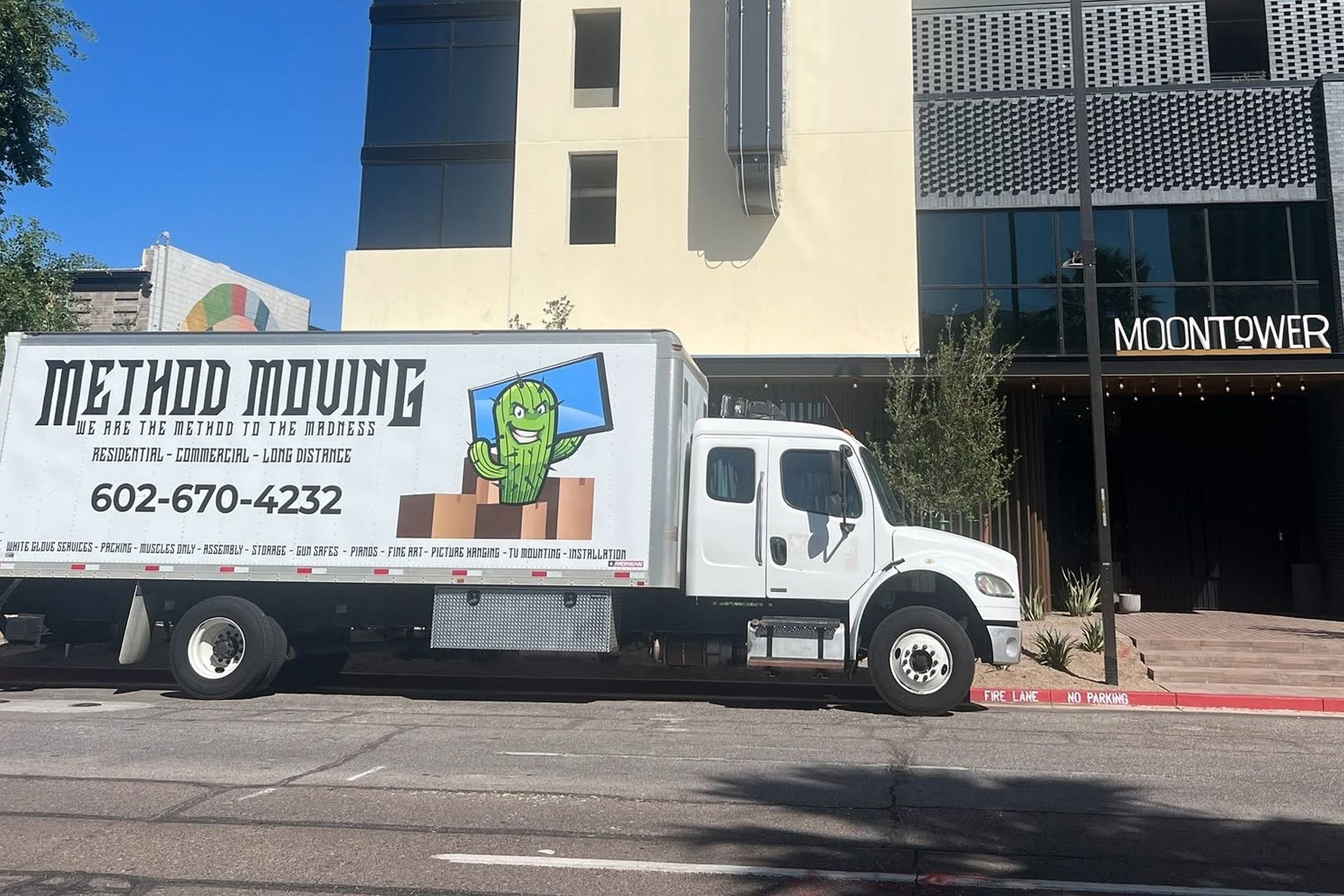 White Method Moving truck parked on a city street in front of a building entrance.
