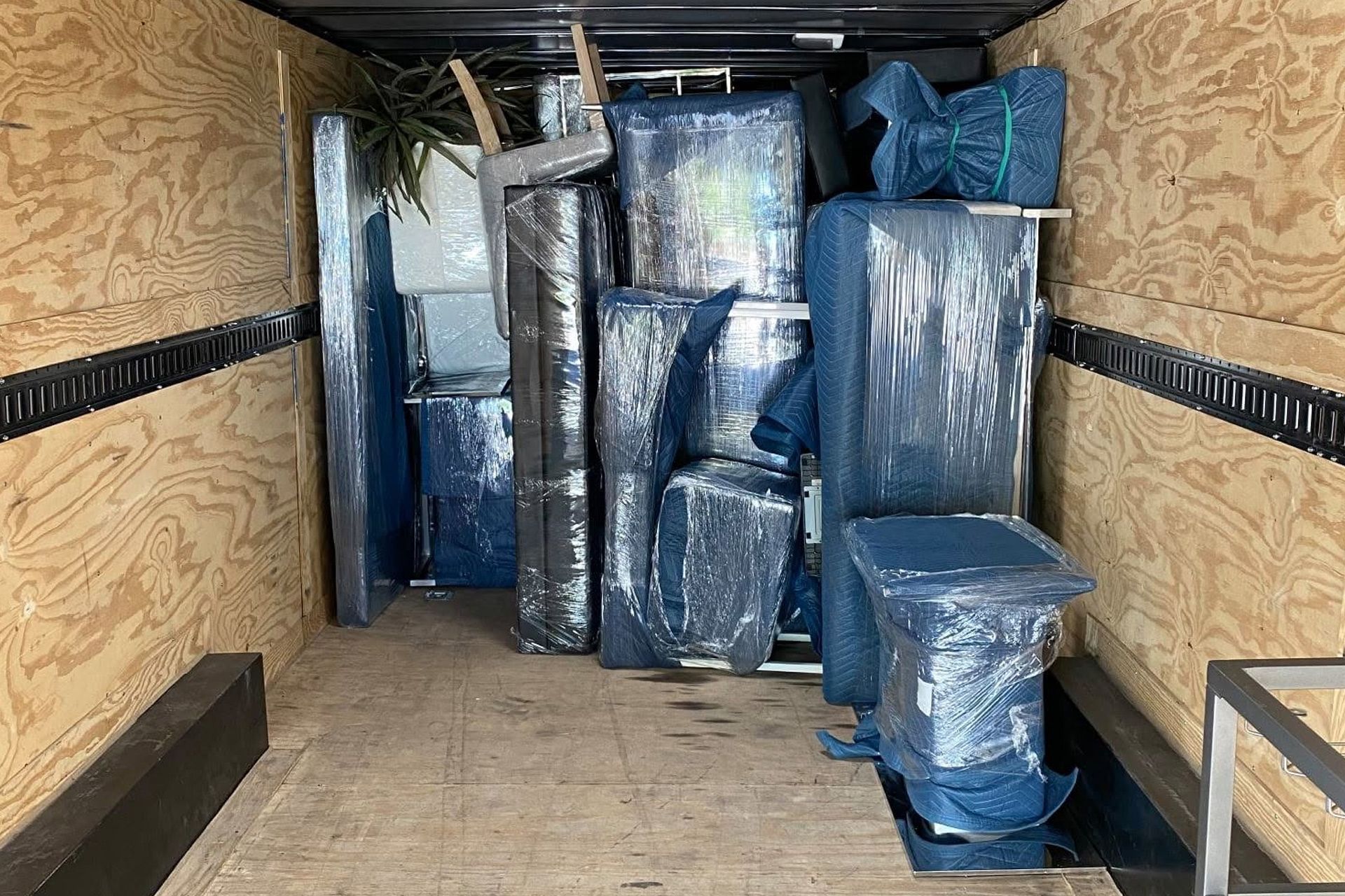 Covered furniture and boxes packed in a truck trailer for moving.