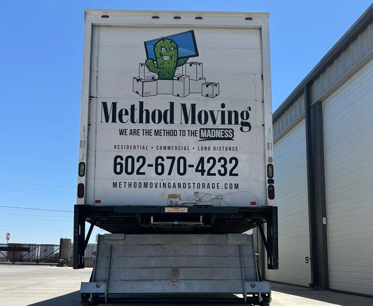Method Moving truck parked outside warehouse, rear door showing logo, phone number, and website.