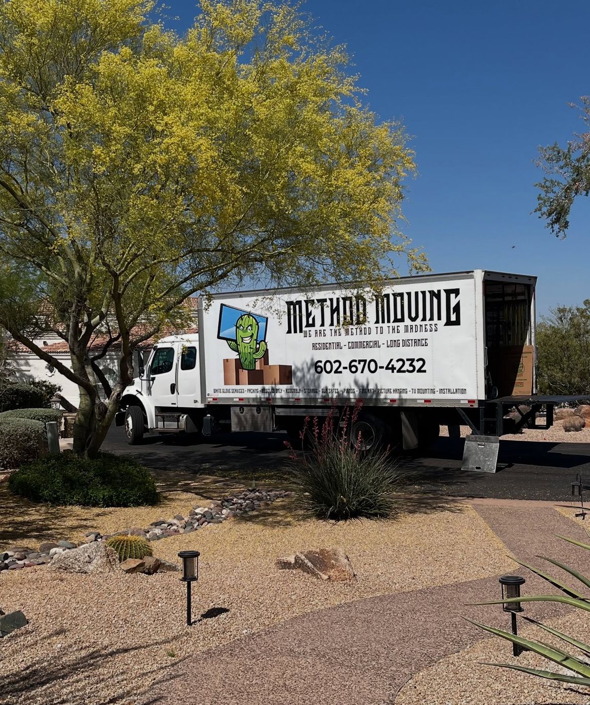 Moving truck with “Method Moving” logo parked in a desert yard under a tree.
