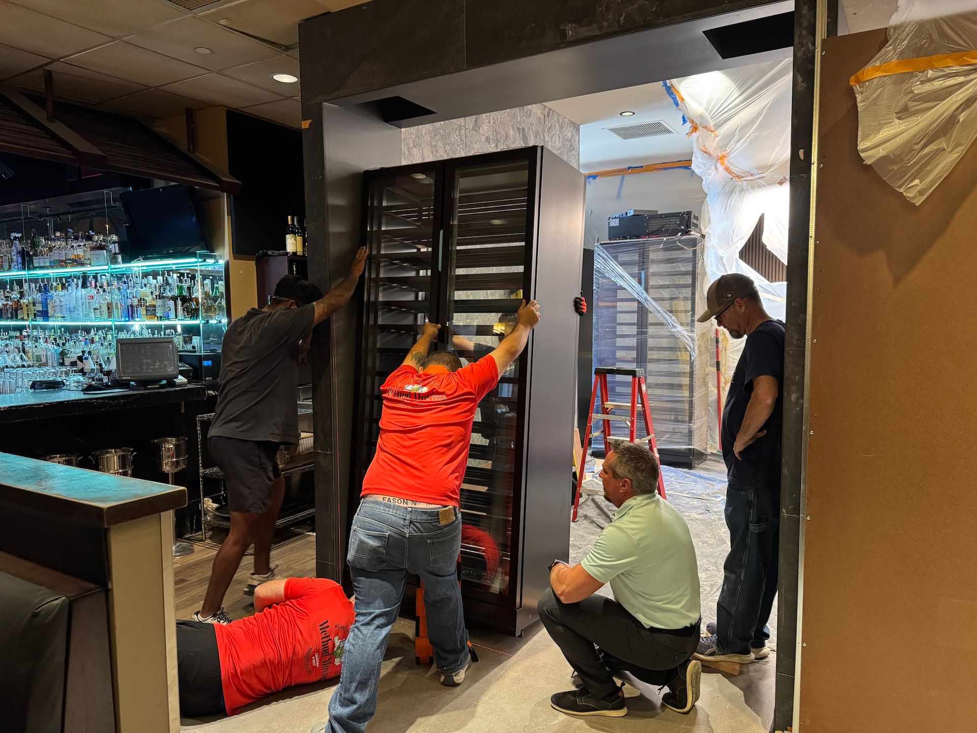 Workers installing a large glass aquarium at a storefront entrance