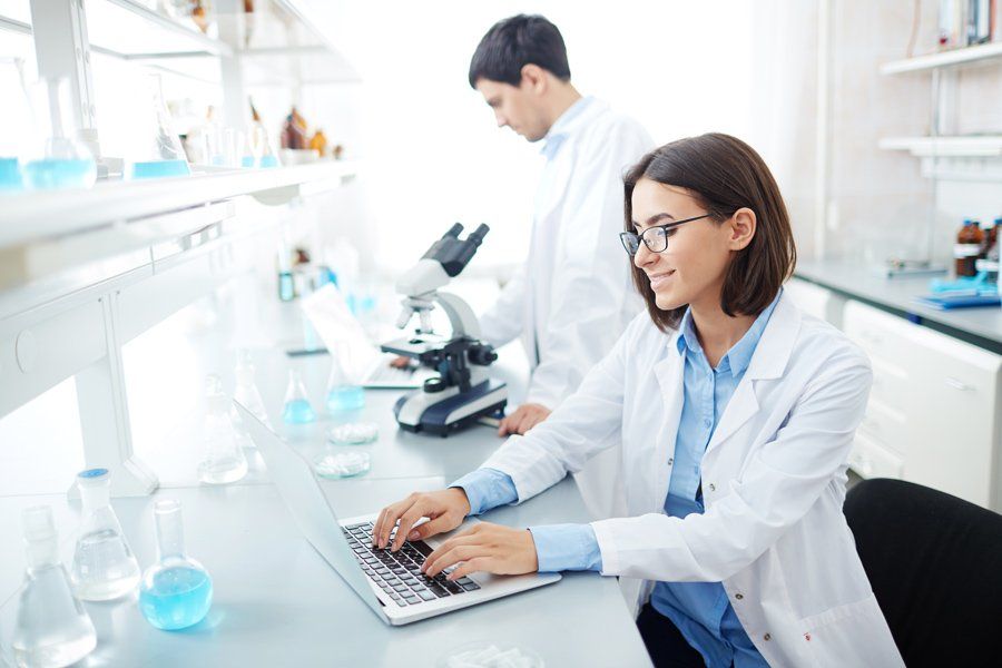 Scientist typing in lab in working environment