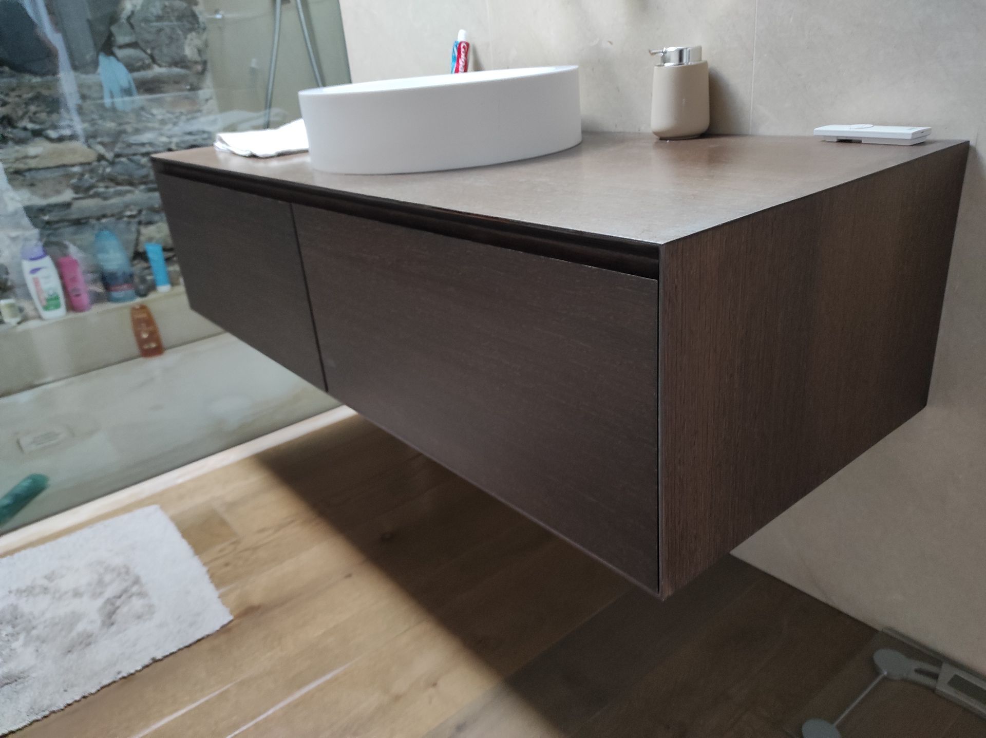 Un bagno con un lavandino e un mobiletto in legno