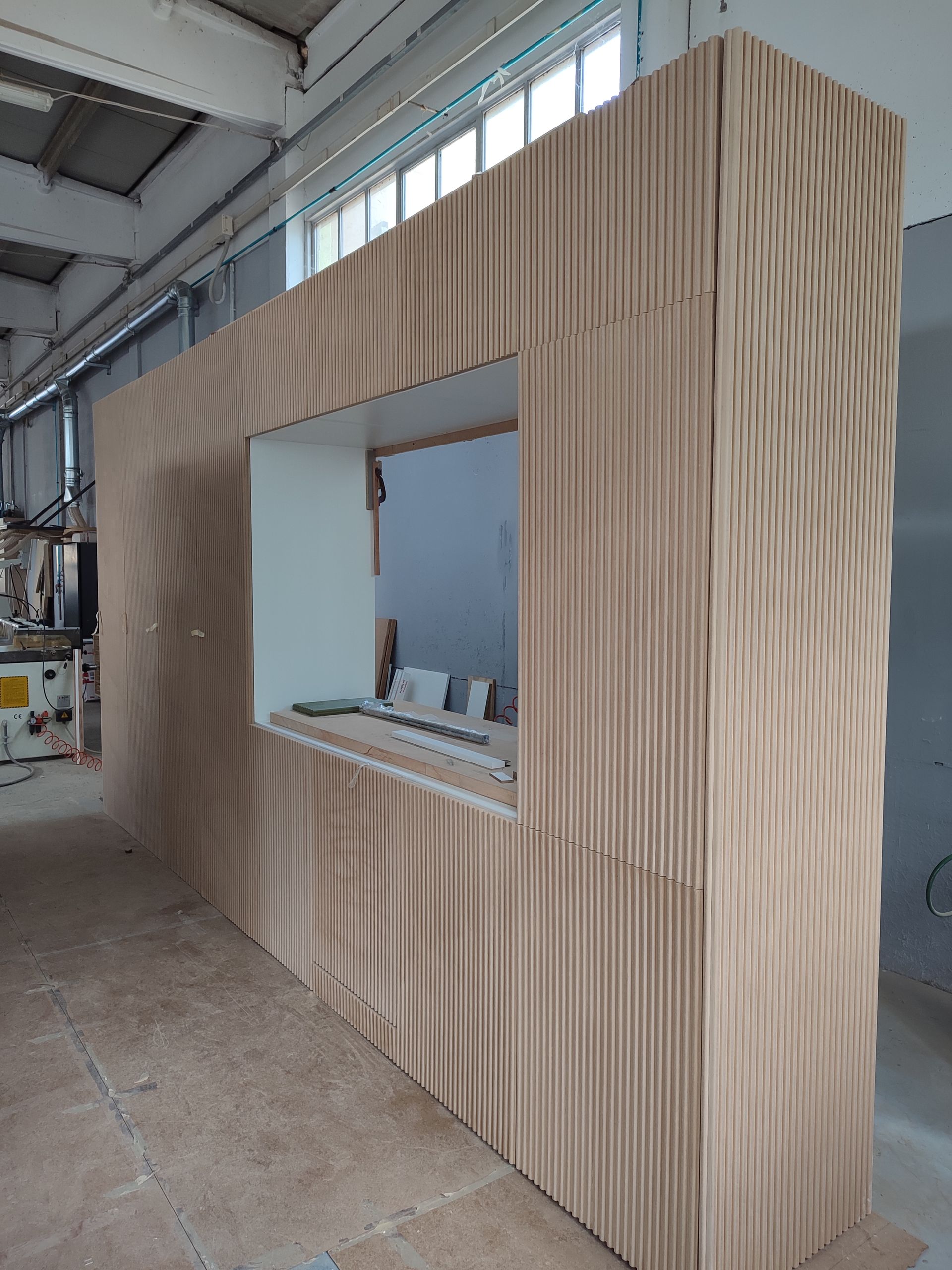 Una grande parete di legno con una finestra al centro.