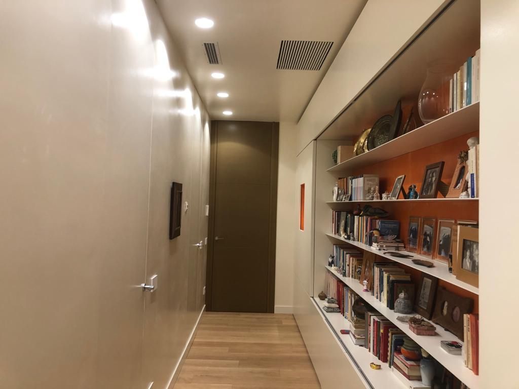 Un corridoio con scaffali pieni di libri e quadri