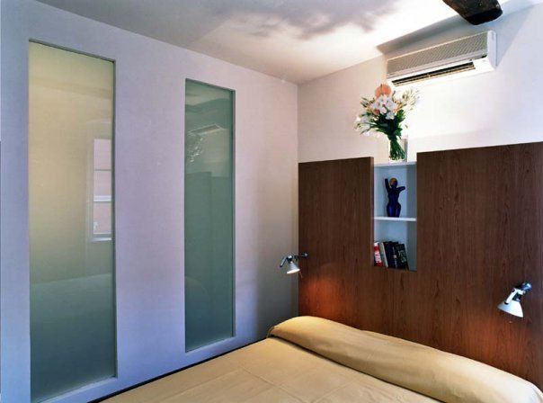 Una camera da letto con un letto e un vaso di fiori sulla testiera