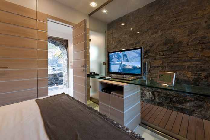 camera da letto con un letto e una televisione su una scrivania.