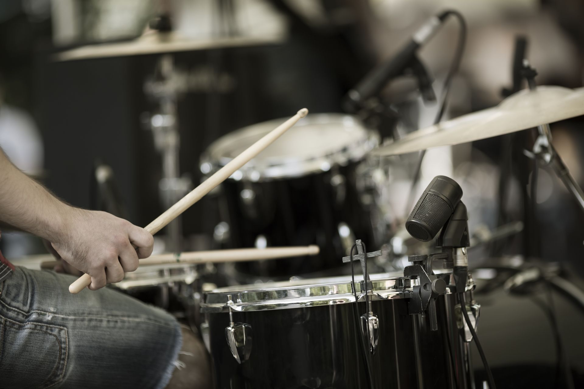 A person is playing drums in front of a microphone.
