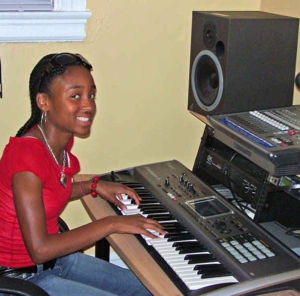 A woman in a red shirt is playing a keyboard