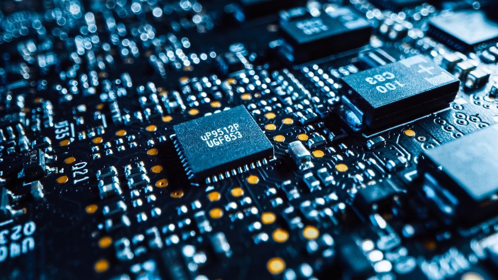 Close-up of a blue circuit board with microchips and glowing electronic components