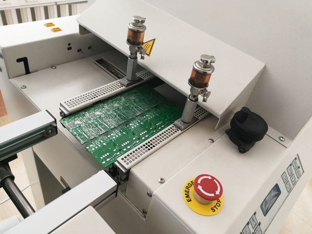 Circuit board inside automated machine with red emergency stop button
