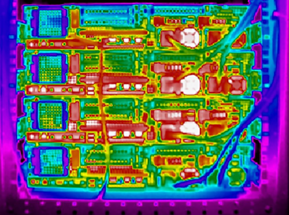 Thermal image of a circuit board showing varying heat levels with bright white and red indicating high temperatures.