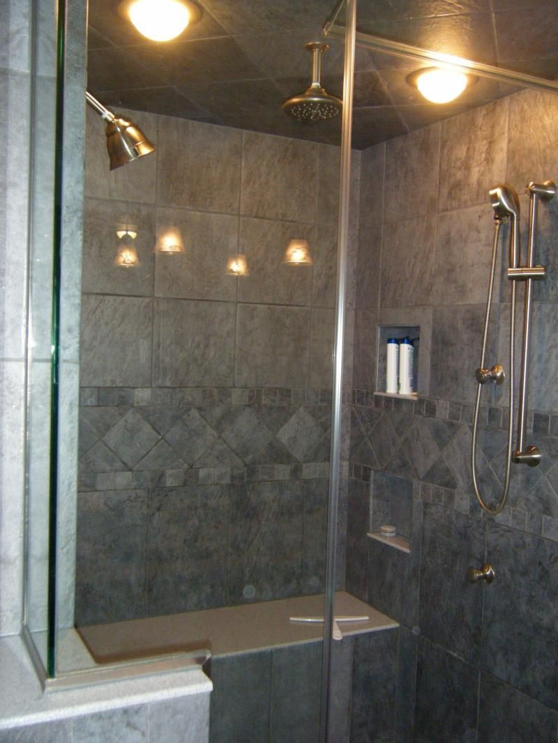 A bathroom with a walk in shower with a glass door