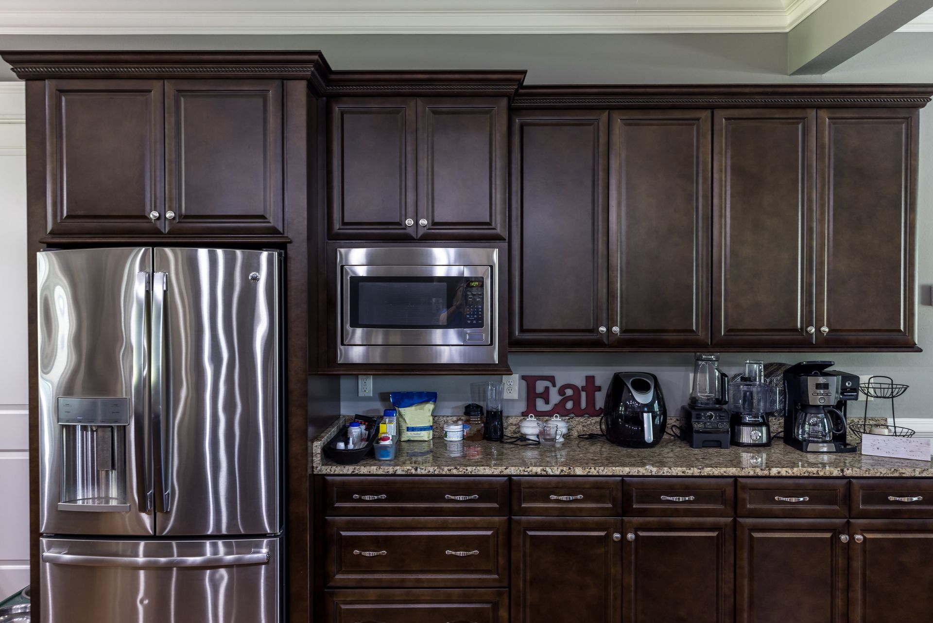 A kitchen with stainless steel appliances and a sign that says eat
