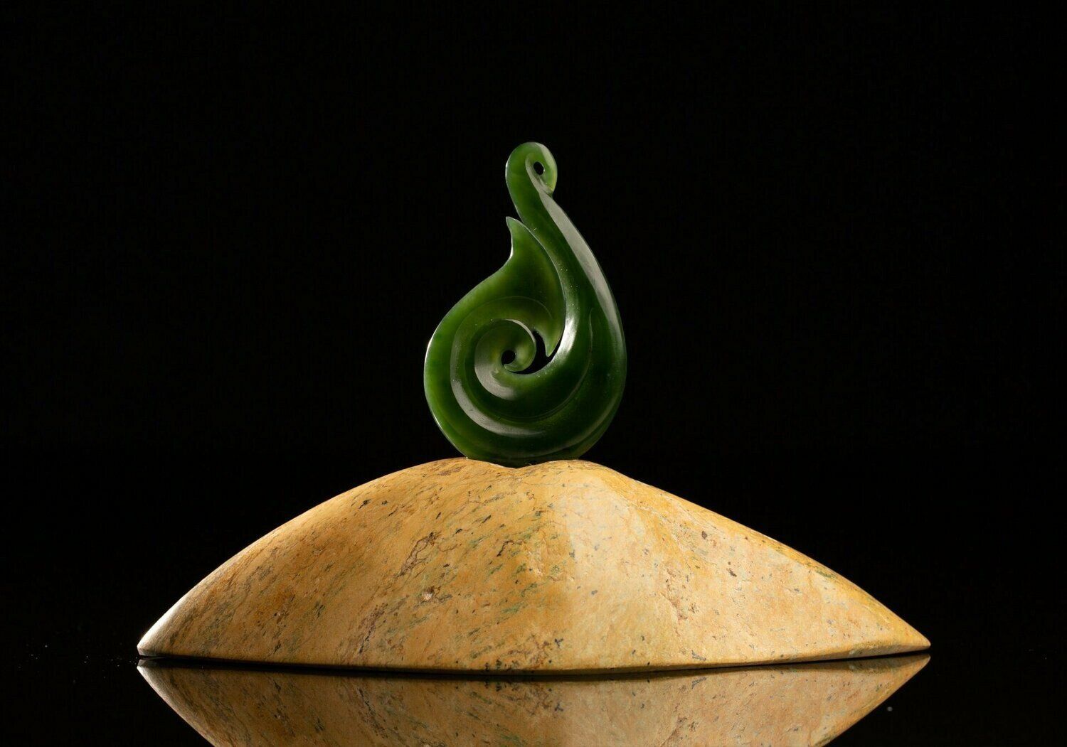 A pounamu sculpture with a matau (hook) design