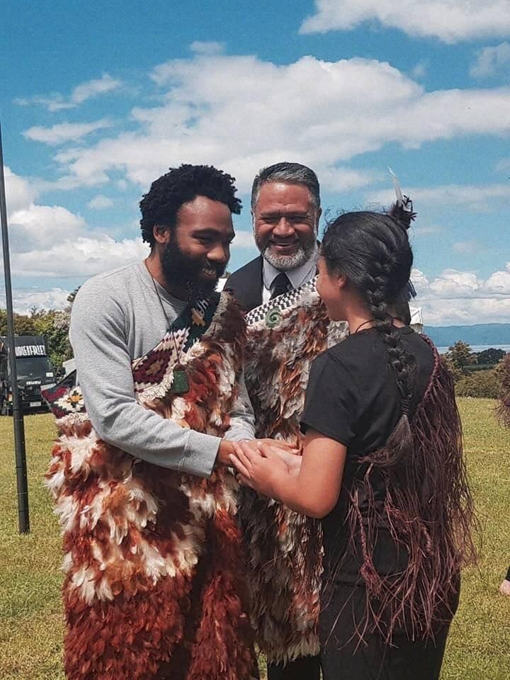 A man and a woman are standing next to each other in a field.