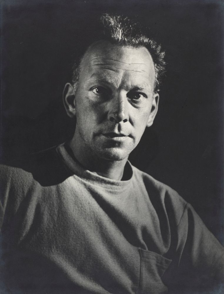 A black and white photo of a man in a grey shirt