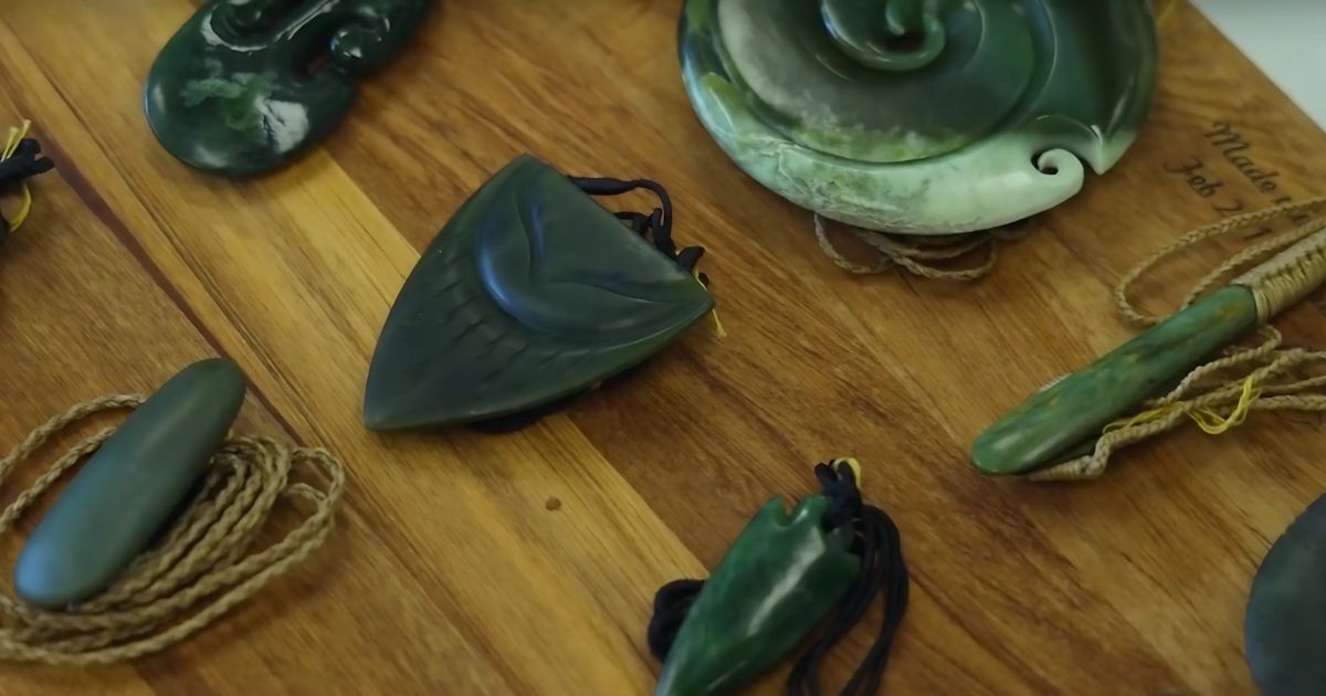 A person is cleaning a green pendant with a cloth
