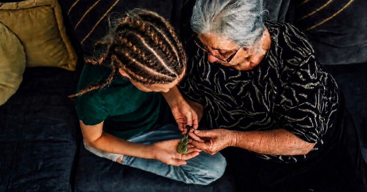 A grandmother sharing a taonga with her mokopuna
