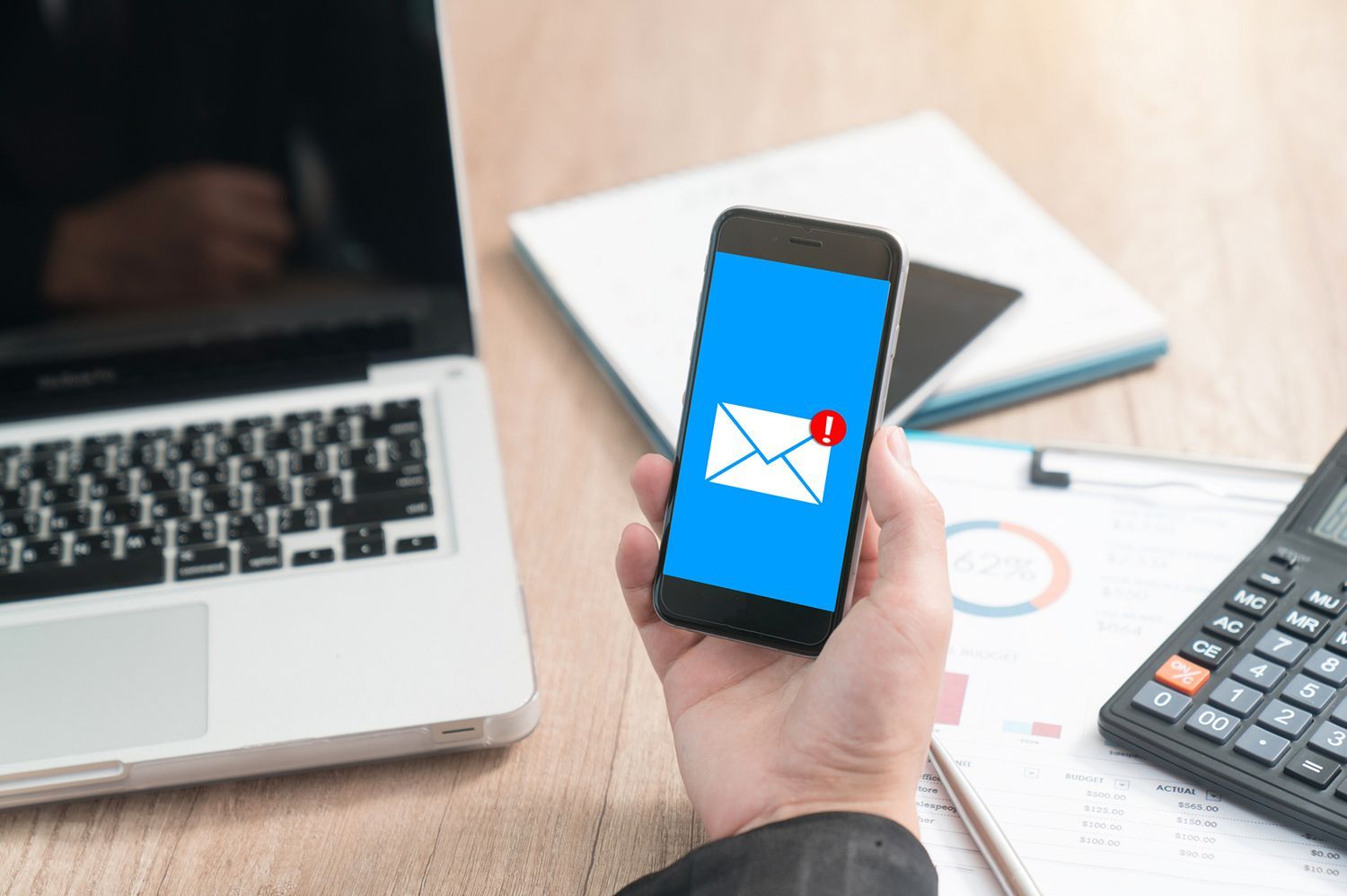 A person is holding a cell phone with an envelope on the screen. A person is holding a cell phone with an envelope on the screen.